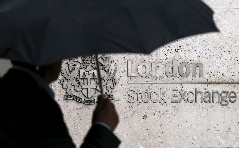 © Reuters. File photo of a man sheltering under an umbrella as he walks past the London Stock Exchange 