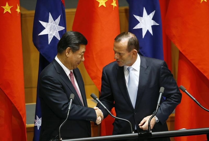 © Reuters. Xi shakes hands with Abbott after a signing ceremony for a free trade deal at Parliament House in Canberra