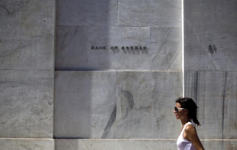 © Reuters. A woman walks past the headquarters of the Bank of Greece in Athens