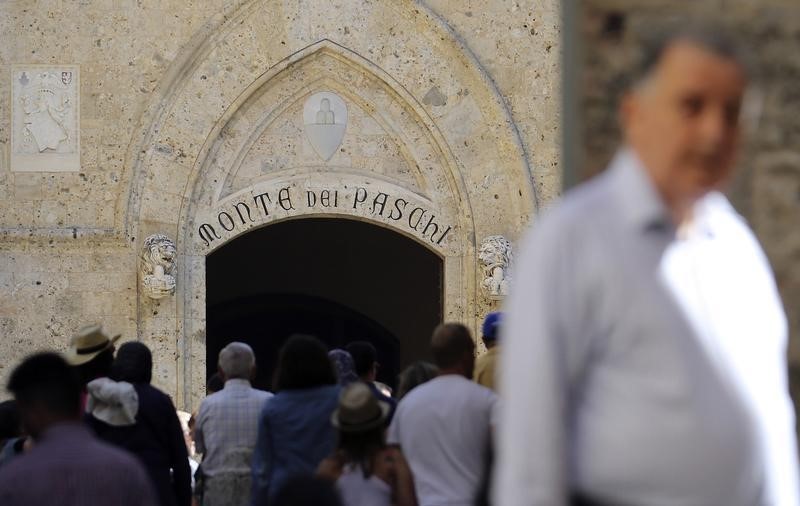 © Reuters. People stand at the entrance of Monte dei Paschi di Siena bank's headquarters in downtown Siena