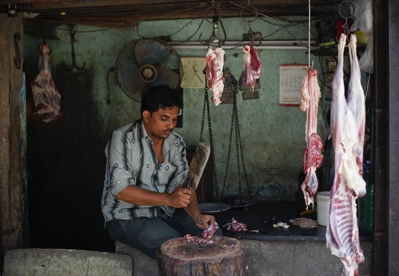 © Reuters. A man chops mutton inside his shop in Mumbai