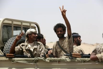 © Reuters. A soldier gestures as he rides on the back of a pick-up truck accompanying Gulf Arab soldiers while they arrive at Yemen's northern province of Marib