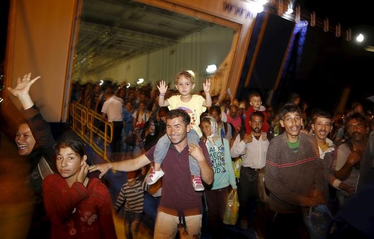 © Reuters. Refugiados e imigrantes desembarcam de um navio no porto de Piraeus