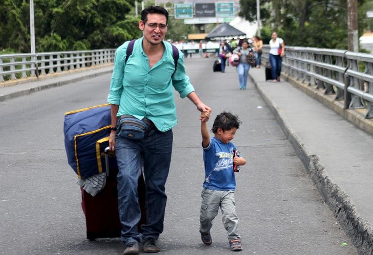 © Reuters. Homem e criança cruzam fronteira da Venezuela para a Colômbia