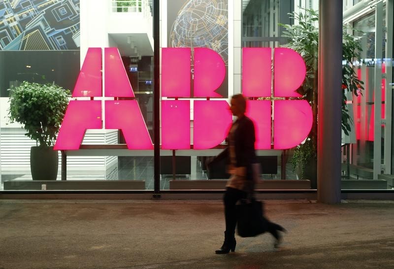 © Reuters. A woman walks past the logo of Swiss industrial group ABB at an office building in Zurich