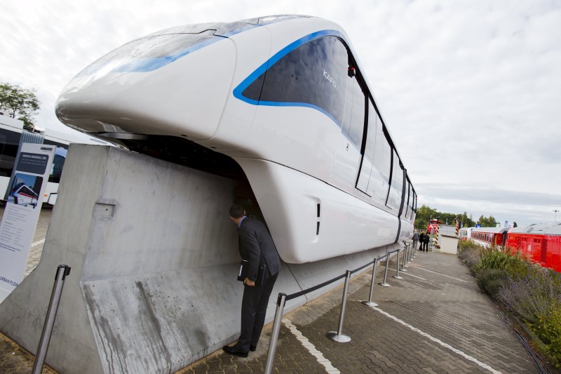 © Reuters. File photo of a man looking underneath an Innovia Monorail 300 train by Bombardier Transportation at the InnoTrans railway technology trade fair in Berlin