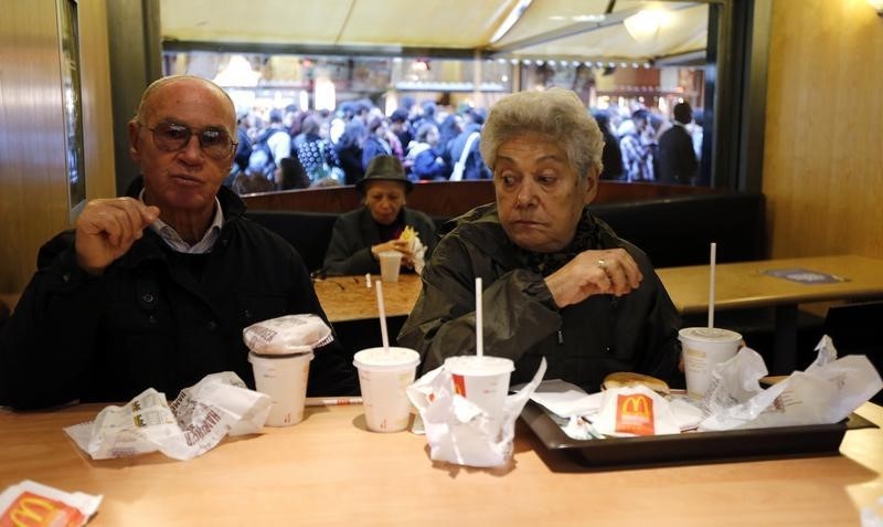 © Reuters. Milano, una coppia di pensionati al McDonald's