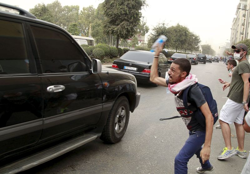 © Reuters. Protesters throw bottles of water at a convoy of Lebanese politicians leaving the parliament building after attending a session of "national dialogue" in downtown Beirut, Lebanon