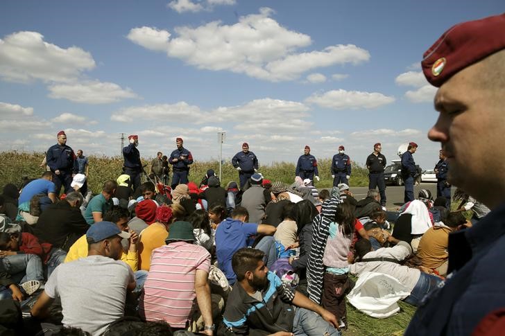 © Reuters. Policiais húngaros observam imigrantes perto de um centro de recepção em Roszke