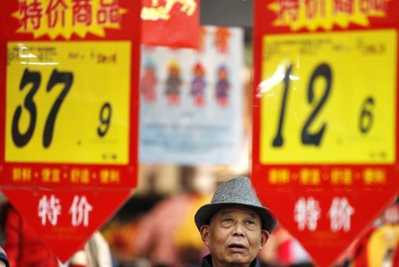 © Reuters. A customer looks at price tags at a supermarket in Huaibei