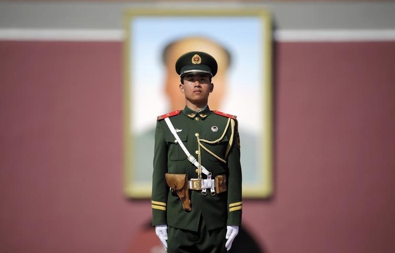 © Reuters. A paramilitary police officer stands guard in front of a giant portrait of China's late Chairman Mao Zedong in Beijing