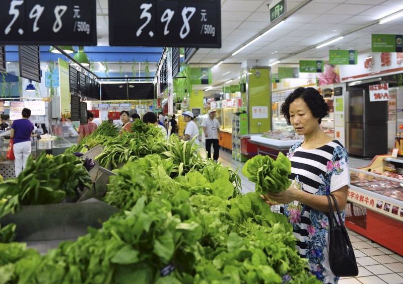 © Reuters. A customer selects vegetable at a supermarket in Hangzhou