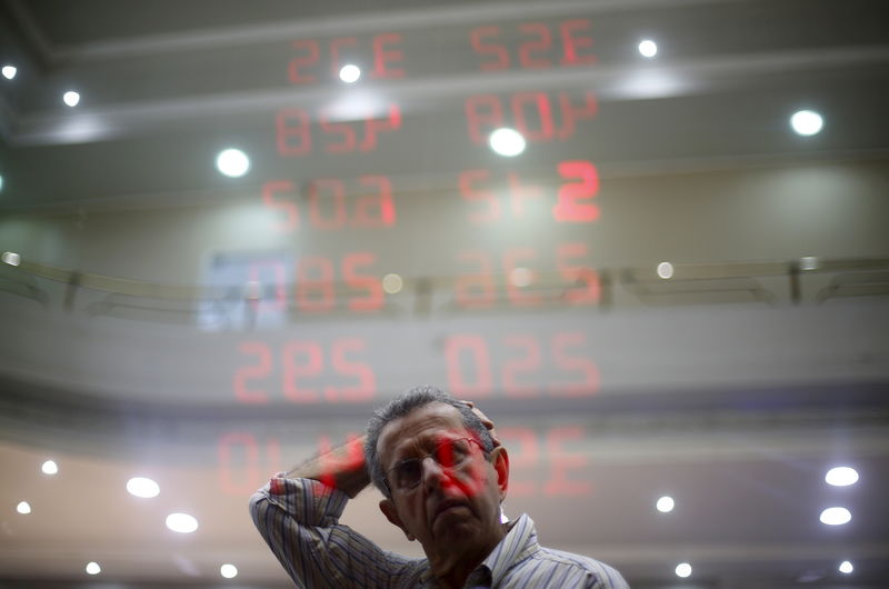 © Reuters. A man reacts as he reads a board showing the Real-U.S. dollar and several foreign currencies exchange rates in Rio de Janeiro