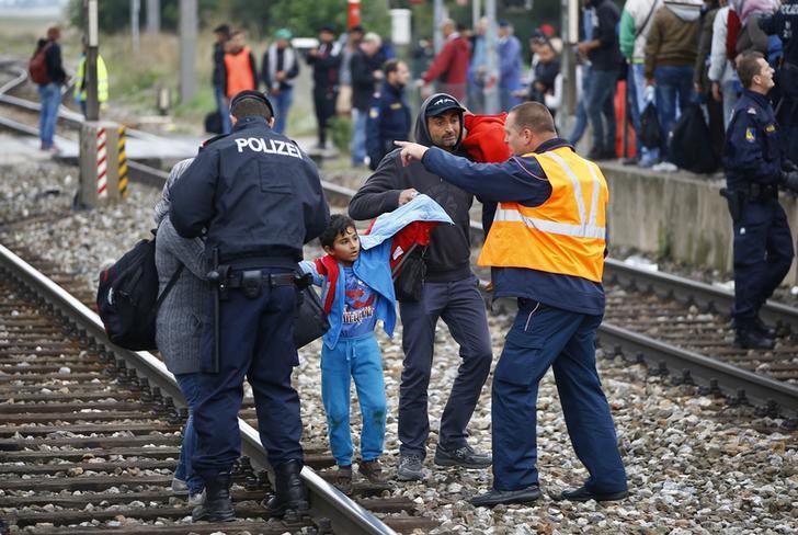 © Reuters. Policiais retirando imigrantes dos trilhos na estação de trem em Nickelsdorf, na Áustria