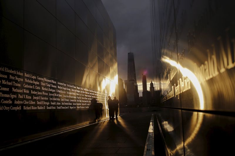 © Reuters. People visit the 9/11 Empty Sky memorial at sunrise across from New York's Lower Manhattan and One World Trade Center, in Liberty State Park in Jersey City, New Jersey