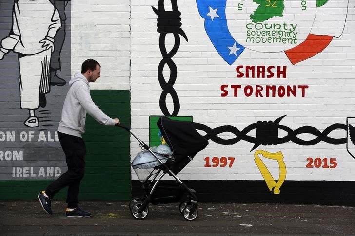 © Reuters. Homem passa por muro pintado em área republicana de Belfast, na Irlanda do Norte