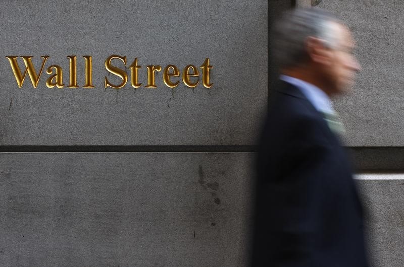 © Reuters. A man walks along Wall Street in New York