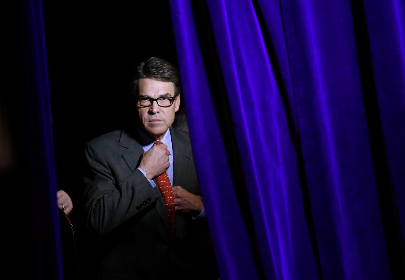 © Reuters. Former Governor of Texas Rick Perry adjusts his tie as he listens to his introduction from the side of the stage at the Freedom Summit in Des Moines