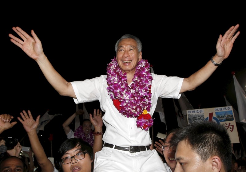 © Reuters. Singapore's Prime Minister and Secretary-General of the People's Action Party Lee Hsien Loong celebrates with supporters after the general election results at a stadium in Singapore