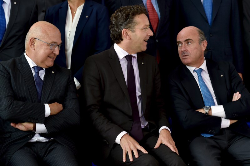 © Reuters. French Finance Minister Sapin and Eurogroup President Dijsselbloem and Spain's Economy Minister de Guindos chat during a family picture at a EU finance ministers meeting in Luxembourg