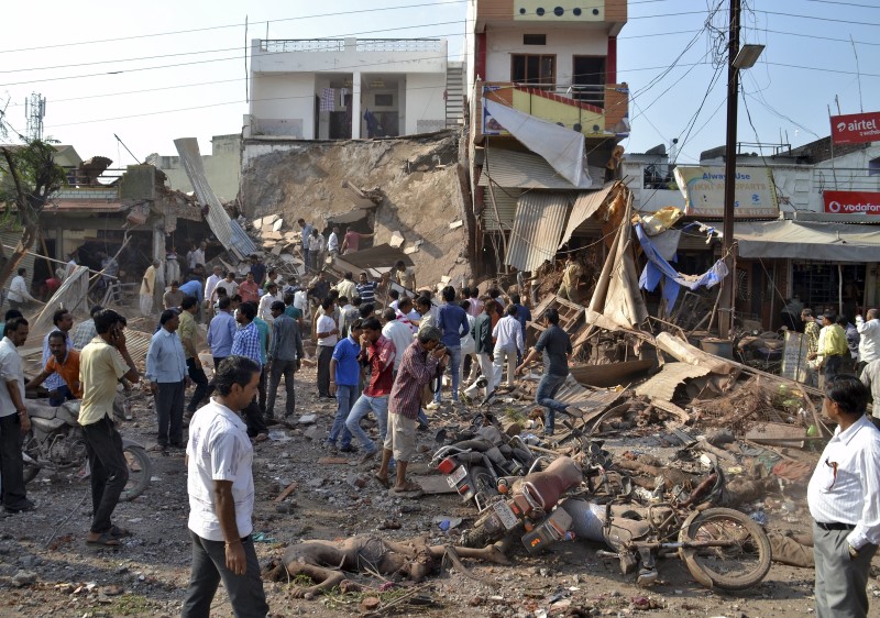 © Reuters. People stand near the site of an explosion in Jhabua district at Madhya Pradesh