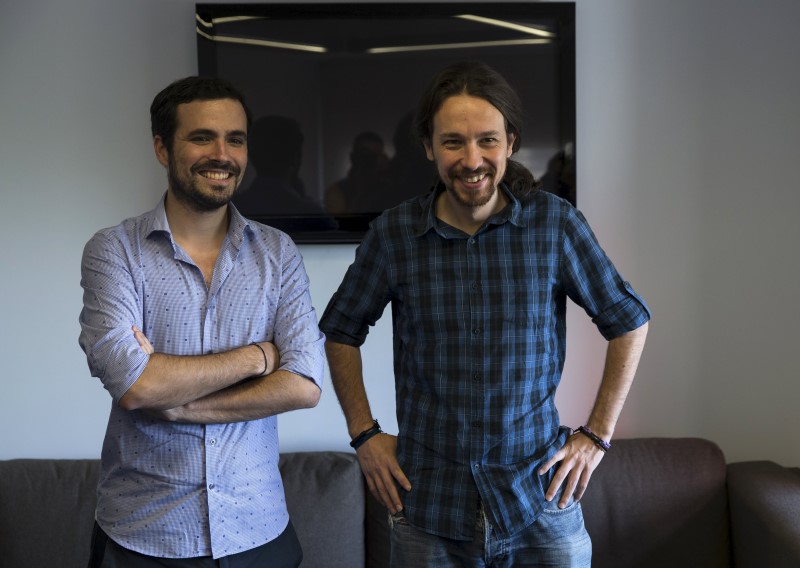 © Reuters. Podemos (We can) party leader Iglesias and Izquierda Unida (United Left) prime ministerial candidate Garzon smile before their meeting in Madrid