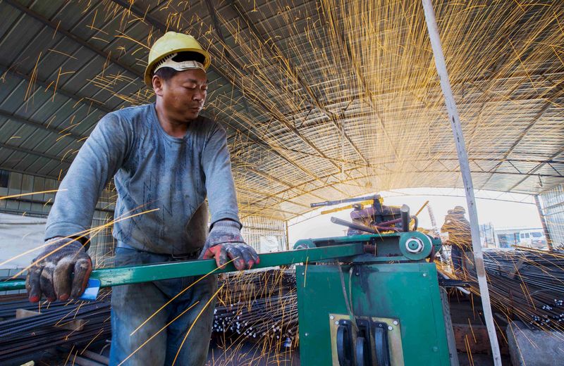 © Reuters. Labourer cuts steel bars at a railway bridge construction site in Lianyungang