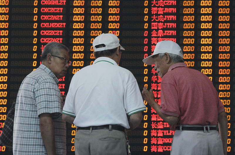 © Reuters. Investors talk in front of an electronic board showing stock information at a brokerage house in Shanghai