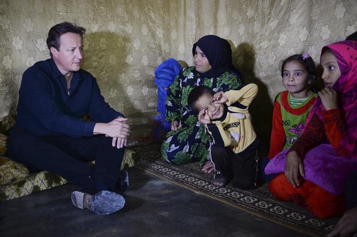 © Reuters. Primeiro-ministro britânico, David Cameron, em encontro com uma família refugiada síria no Líbano