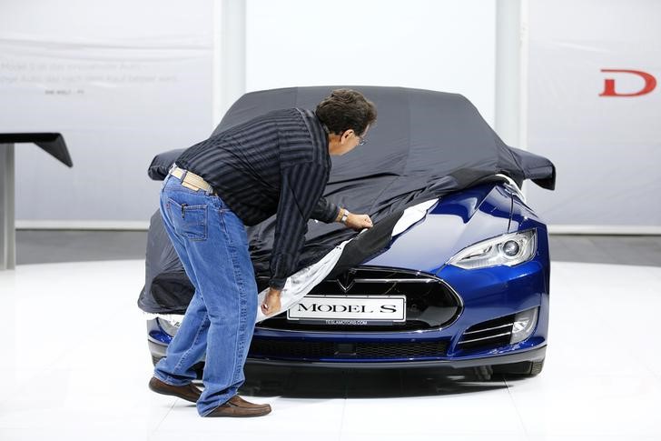 © Reuters. An employee covers a Tesla Model S car during the media day at the Frankfurt Motor Show (IAA) in Frankfurt