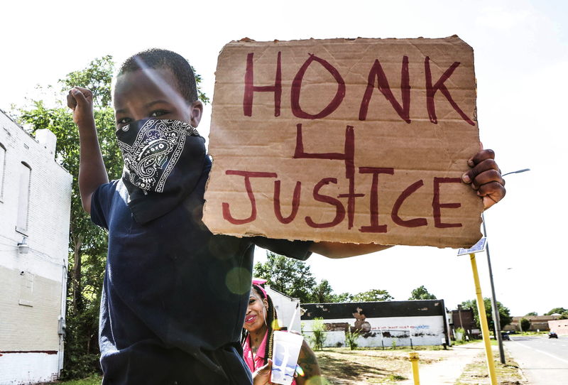 © Reuters. A boy holds a sign at the corner of Walton and Page in St. Louis