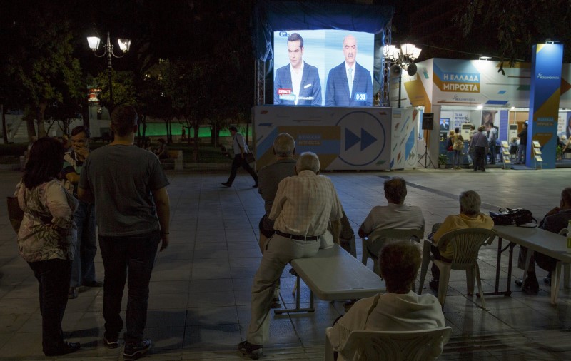 © Reuters. People watch a televised electoral debate in Syntagma square in Athens 