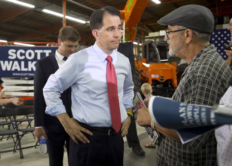 © Reuters. Republican presidential candidate Wisconsin Gov. Scott Walker (C) listens to Steve Small following a town hall meeting at the Xtreme Manufacturing warehouse in Las Vegas