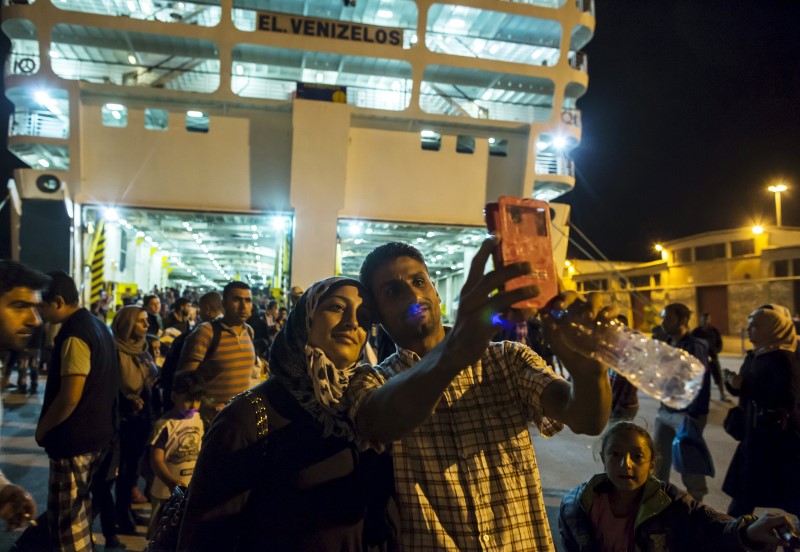 © Reuters. Ihab, a 30-year old Syrian migrant from Deir Al Zour, war-torn Syria, takes a selfie with his wife Abeer after disembarking from a passenger ship in Athens, Greece