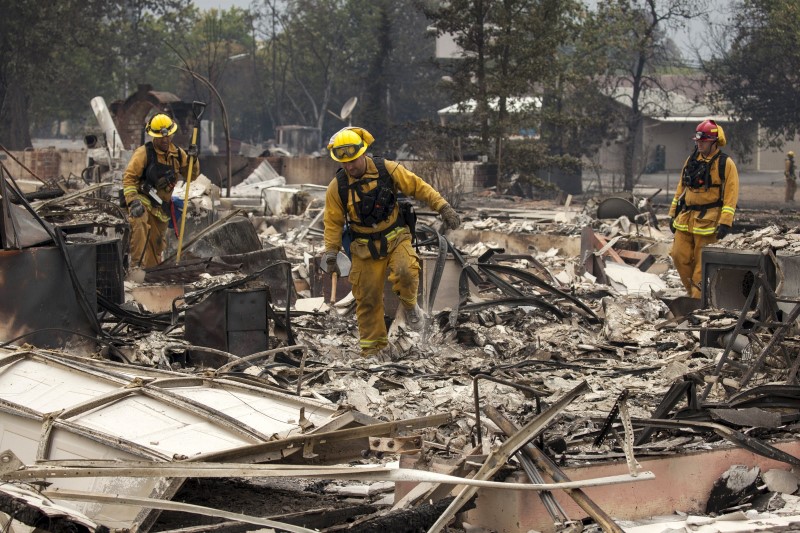 © Reuters. Bombeiros buscam vítimas em casa queimada em Valley Fire, Middletown