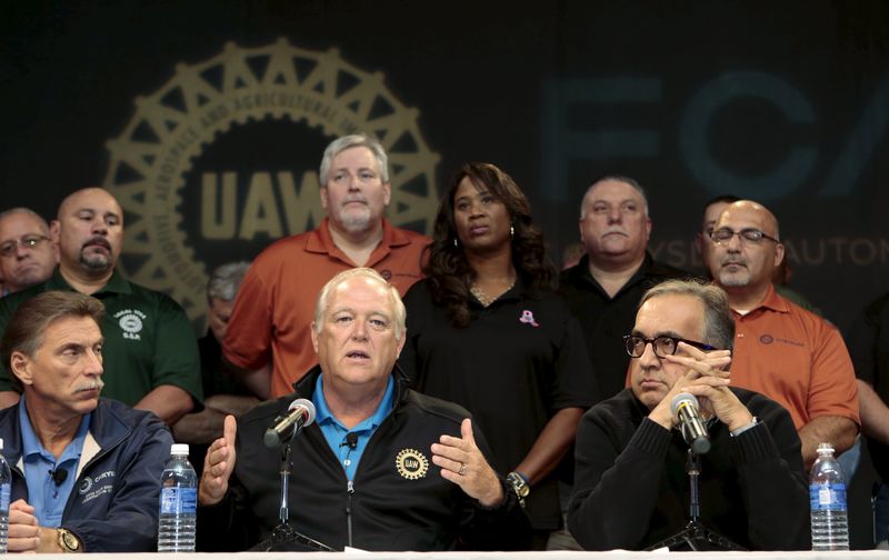 © Reuters. United Auto Workers (UAW) President Dennis Williams (front C) and Fiat Chrysler Automobiles (FCA) CEO Sergio Marchionne (front R) hold a news conference to announce a tentative agreement in Detroit, Michigan