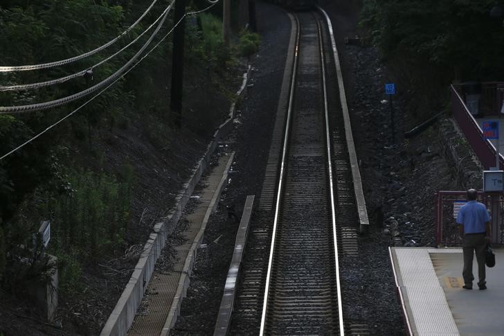 © Reuters. Empty Long Island Railroad tracks are seen as a man waits for a train bound for Pennsylvania Station in Manhasset, New York