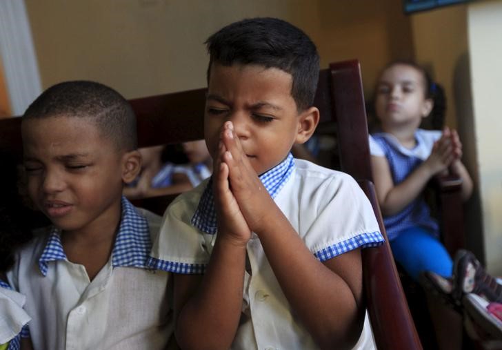 © Reuters. Children pray at the Father Usera daycare center in Havana