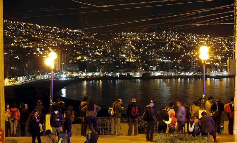 © Reuters. Pessoas observam oceano de cima do morro Cerro Baron, na cidade litorânea de Valparaíso 