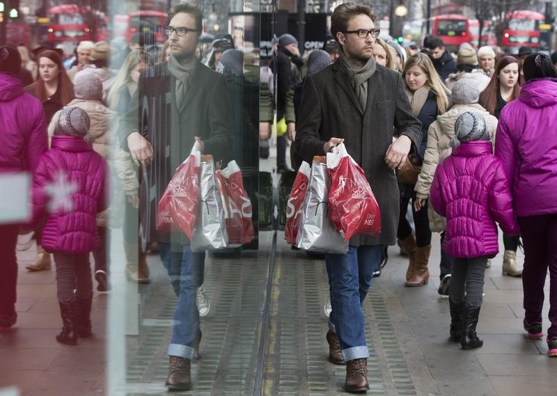 © Reuters. A shopper is reflected in a store window on Oxford Street in central London