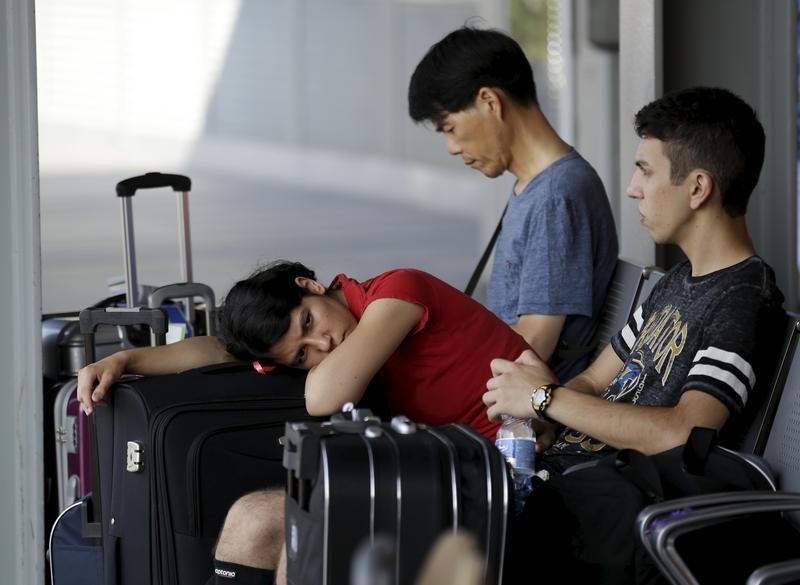 © Reuters. Passeggeri in attesa all'aeroporto di Fiumicino