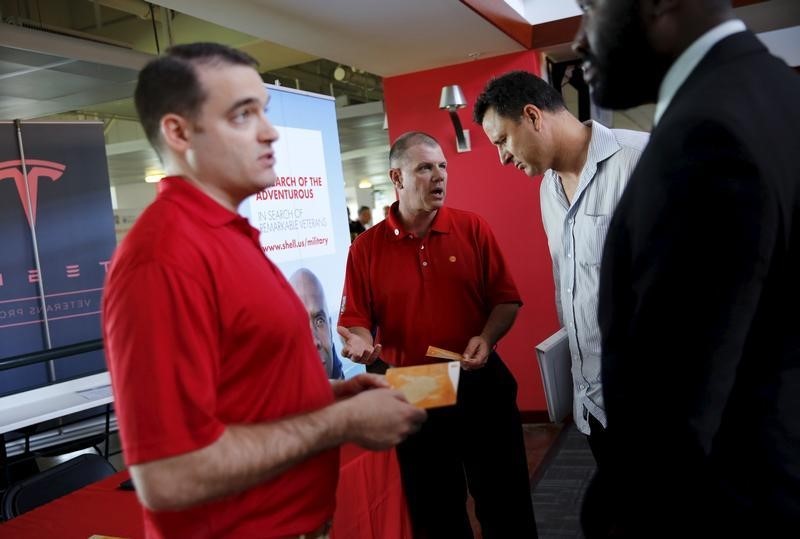 © Reuters. Recruiters from Shell Oil talk with job seekers at a military job fair in San Francisco