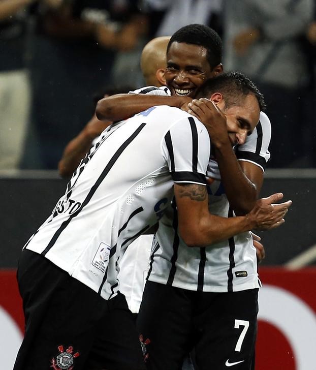 © Reuters. Renato Augusto recebe abraço de Elias em jogo do Corinthians na Copa Libertadores