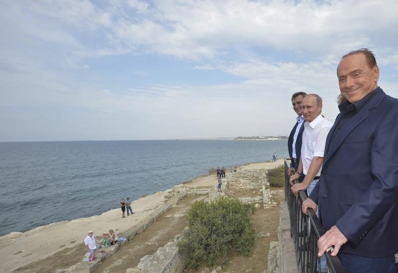 © Reuters. L'ex premier Silvio Berlusconi (terzo a destra) con il presidente russo Vladimir Putin (al centro) a Sevastopol in Crimea 