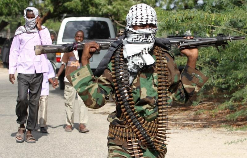 © Reuters. A member of Somalia's al Shabaab rebel group walks with a machine gun after attending Eid al-Adha prayers north of Mogadishu