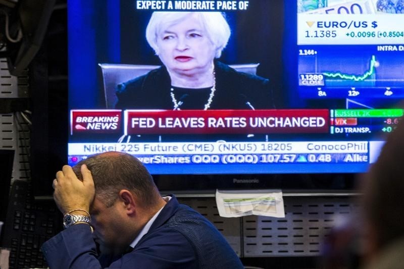 © Reuters. Un trader lavora mentre la tv trasmette la notizia dei tassi invariati Fed 