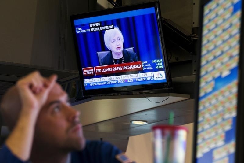 © Reuters. Un operatore a lavoro mentre sulla tv il governatore Janet Yellen annuncia la decisione della Fed di mantenere i tassi Usa invariati 