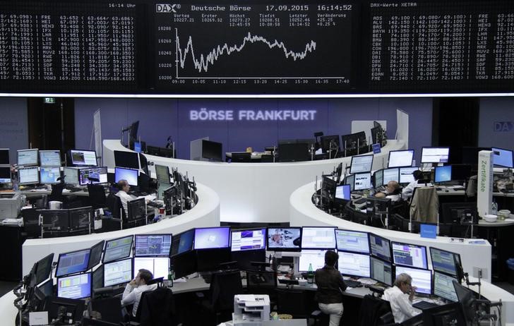 © Reuters. Traders are pictured at their desks in front of the DAX board at the stock exchange in Frankfurt