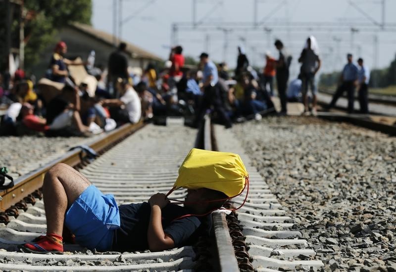 © Reuters. مئات المهاجرين ينتظرون على الجانب الكرواتي من الحدود مع المجر