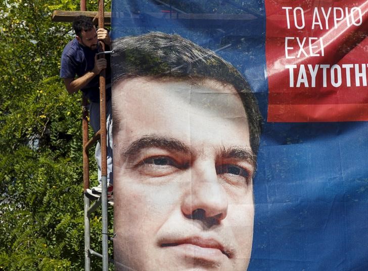 © Reuters. Trabalhador prende cartaz de campanha do ex-premiê grego Alexis Tsipras em Atenas